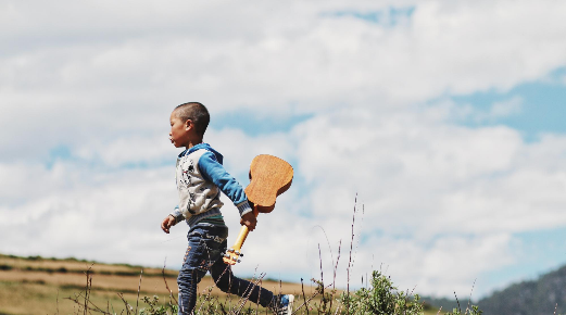 "Boy Running While Holding a Ukulele" by kychan on unsplash